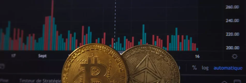 Monedas con el logo de Bitcoin y ethereum delante de ordenador con pantalla de inversiones.