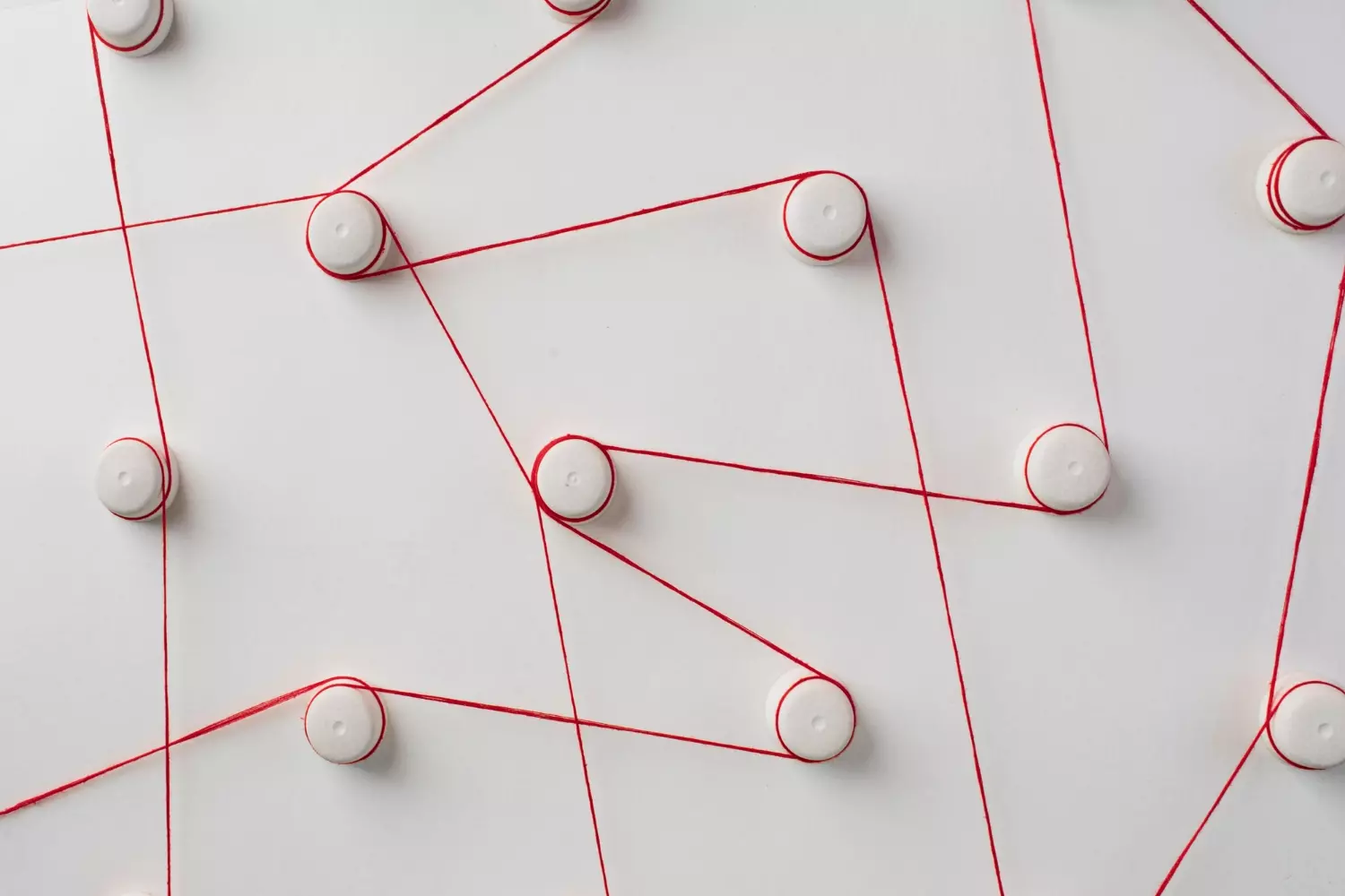 Hilo rojo en forma de red sobre fondo blanco.