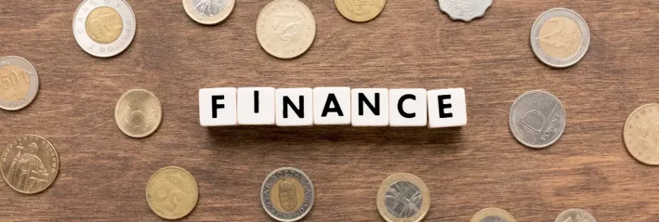 Fichas que forman la palabra "Finance" con monedas de varios países.