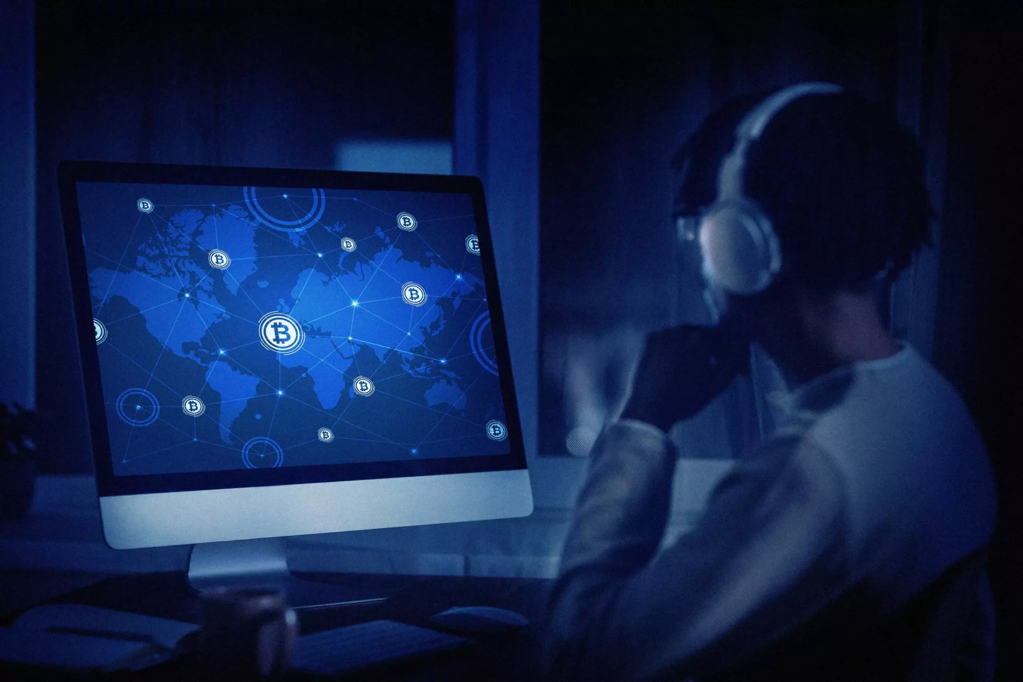 Hombre mirando pantalla donde aparece un mapa con la red mundial de bitcoin