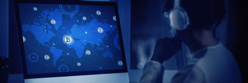 Hombre mirando pantalla donde aparece un mapa con la red mundial de bitcoin