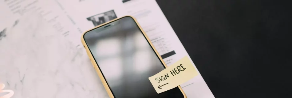 Teléfono móvil con una nota que dice "firmar aquí"
